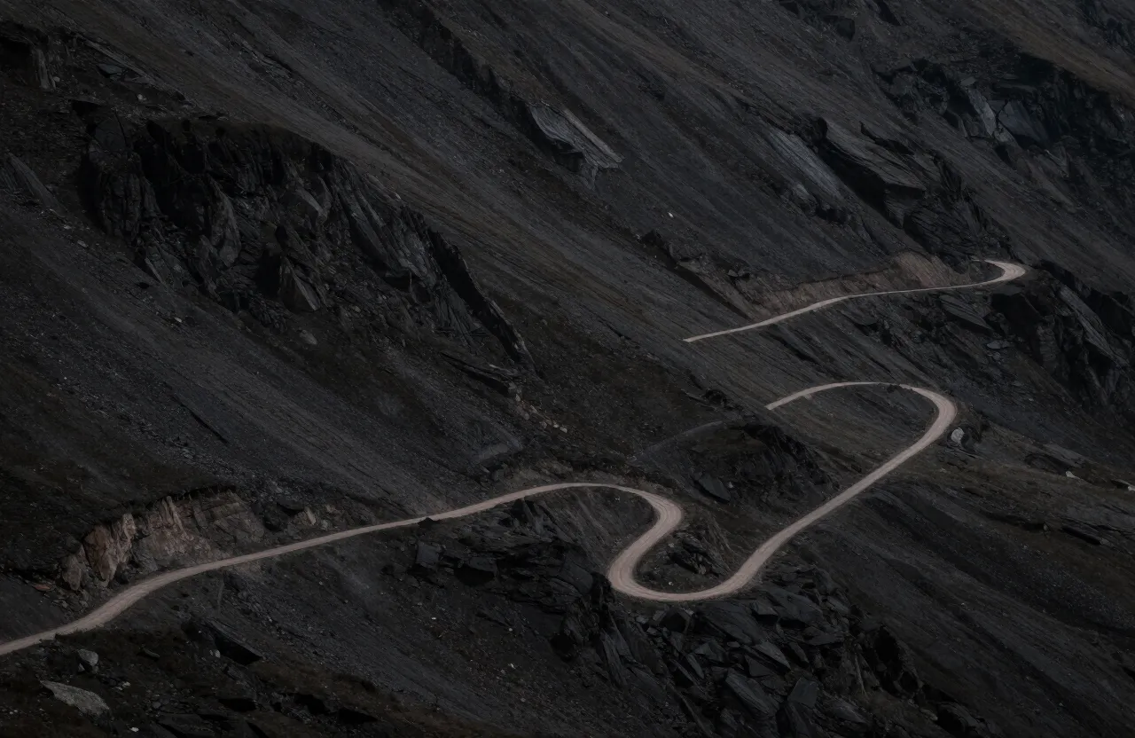 Sendero de zigzag visto desde arriba en una ladera oscura